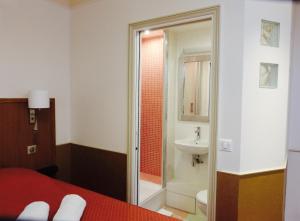 a bathroom with a bed and a shower and a sink at Hôtel Marignan in Paris