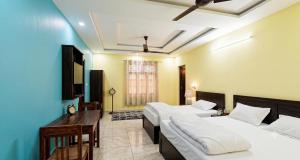 a hotel room with two beds and a television at Hotel Almora Palace in Almora