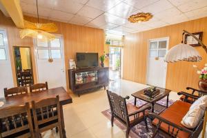 a living room with a television and a table and chairs at Di Mo homestay Citadel Conner in Thôn Kim Long (1)