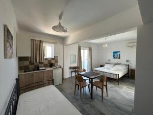 a room with a kitchen and a table and a bed at Kaloxenia in Kardamaina