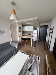 a living room and kitchen with a couch and a table at Bello departamento av del mar in Coquimbo