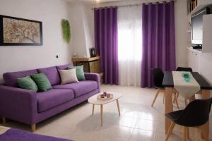 a living room with a purple couch and a table at Domenica apartment in Salamina