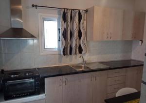 a small kitchen with a sink and a microwave at Domenica apartment in Salamina +2 photos