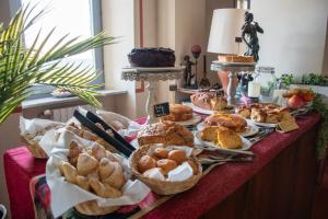 a table with various pastries and breads on it at Hotel Oviv - La dimora del Borgo in Acquaviva Picena