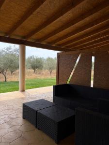 a patio with black benches and a wooden roof at Herdade do Serra in Ervidel