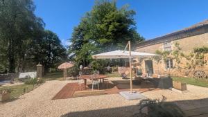 a patio with a table and an umbrella at L'héritage in Champdeniers