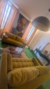a living room with a couch with a painting of a woman at L'héritage in Champdeniers