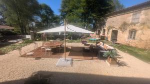 a patio with a table and an umbrella at L'héritage in Champdeniers +2 photos