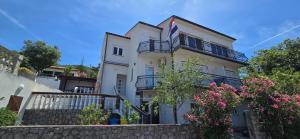 a white house with balconies and flowers at Karmen 2 in Sveti Juraj