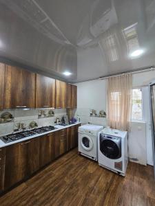 a kitchen with a stove and a washing machine at Guesthouse Sunshine Ureki in Ureki