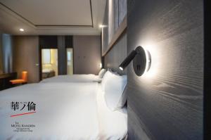 a hotel room with a bed with a light on the wall at 華倫汽車旅館 in Erlin