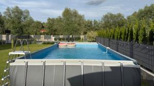 a swimming pool with two boats in a yard at Albian Apartamenty in Jantar