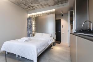 a bedroom with a white bed and a sink at Resume apartments in Kaunas