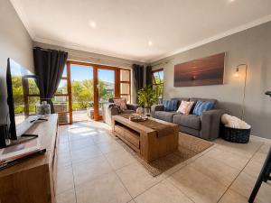 a living room with a couch and a table at Captains Quarters in Plettenberg Bay