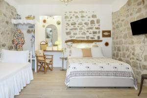 a bedroom with two beds and a desk at Sokaki Patmos in Skala