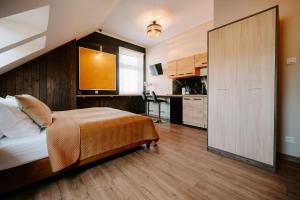 a bedroom with a large bed and a kitchen at Diamond Boutique Hotel in Pruszcz Gdański