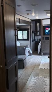 an open door of an rv with a bed and a couch at كرفان نور القمر in Al Namas