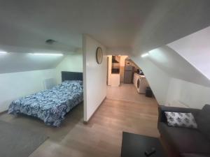 a bedroom with a blue bed and a staircase at Spacieux studio in Montlhéry