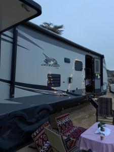 a rv with a table and chairs and a table and chairsitures at كرفان نور القمر in Al Namas +16 photos