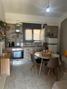 a kitchen with a table and chairs and a table and a kitchen at To Balkoni Thanos in Thános