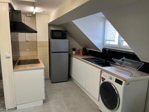 a kitchen with a stove and a washer and dryer at Spacieux studio in Montlhéry