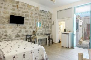 a bedroom with a bed and a stone wall at Sokaki Patmos in Skala