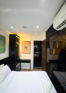 a bedroom with a white bed and a desk at Luxe Apartments Surulere in Lagos