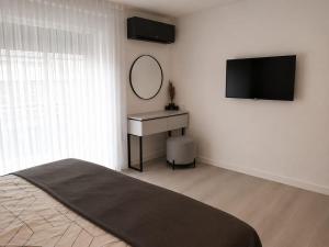 a bedroom with a bed and a mirror and a desk at TML House in Boom