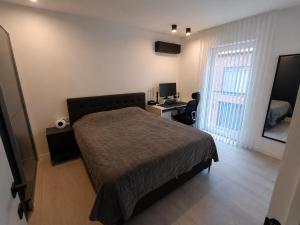 a bedroom with a bed and a desk with a computer at TML House in Boom +11 photos