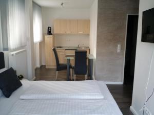 a bedroom with a bed and a table and a kitchen at HD City Apartments in Heidelberg
