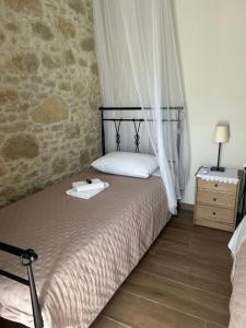 a bedroom with a bed and a stone wall at Fanouria's home in Kalleryianá