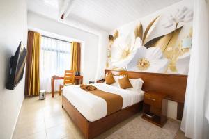 a bedroom with a bed with a flower painting on the wall at The Kyaka Hotel in Machakos