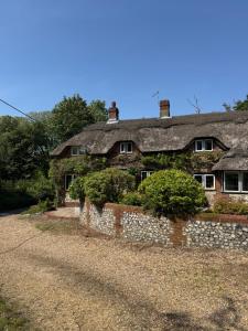 an old stone house with a stone wall at 3 Bedrooms, 3 Double Beds, 6 Guests, Countryside Thatched Cottage in Four Marks