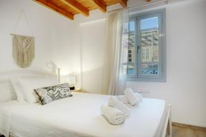 a bedroom with a white bed with towels on it at Consolato House in Patmos