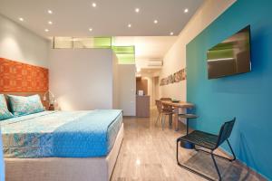 a bedroom with a bed and a chair and a table at Aptera Beach in Amoudara Herakliou