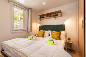 a bedroom with a large white bed with yellow pillows at Club del Sole Viareggio Family Collection in Torre del Lago Puccini +52 photos