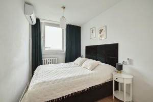 a bedroom with a large bed and a window at Apartament Teatralny - Komfort w Sercu Miasta Klimatyzacja in Opole