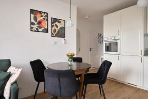 a kitchen and dining room with a table and chairs at Apartament Teatralny - Komfort w Sercu Miasta Klimatyzacja in Opole +18 photos