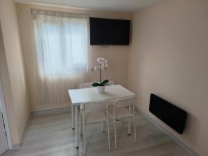 a white table and chairs in a room with a window at Yunus in Croydon