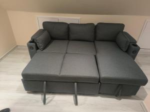 a black couch in a living room at Yunus in Croydon +1 photo