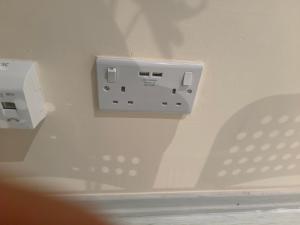 a white electrical outlet on a white wall at Yunus in Croydon