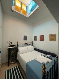 a bedroom with a bed with white sheets and a window at Cycladic House with Aegean Sea View in Aegiali