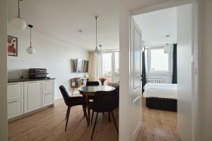 a kitchen and dining room with a table and a bed at Apartament Teatralny - Komfort w Sercu Miasta Klimatyzacja in Opole