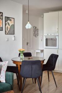 a kitchen and dining room with a table and chairs at Apartament Teatralny - Komfort w Sercu Miasta Klimatyzacja in Opole