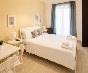a bedroom with a large white bed and a window at Torrearsa 17 in Trapani