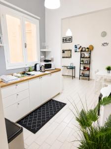 a kitchen with white cabinets and a counter top at Torrearsa 17 in Trapani