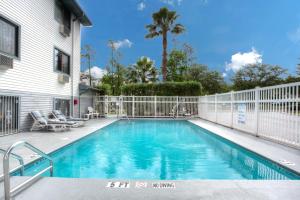 una piscina frente a una casa con una valla en Super 8 by Wyndham Gainesville, en Gainesville