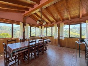 a dining room with a table and chairs and windows at Casa Rural Istikot in Errazu +34 photos