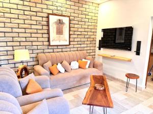 a living room with a couch and a brick wall at Highland by Gunner Lodges in Patriata