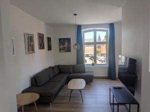 a living room with a couch and a table at Stubbekøbing Square View Stopover in Stubbekøbing